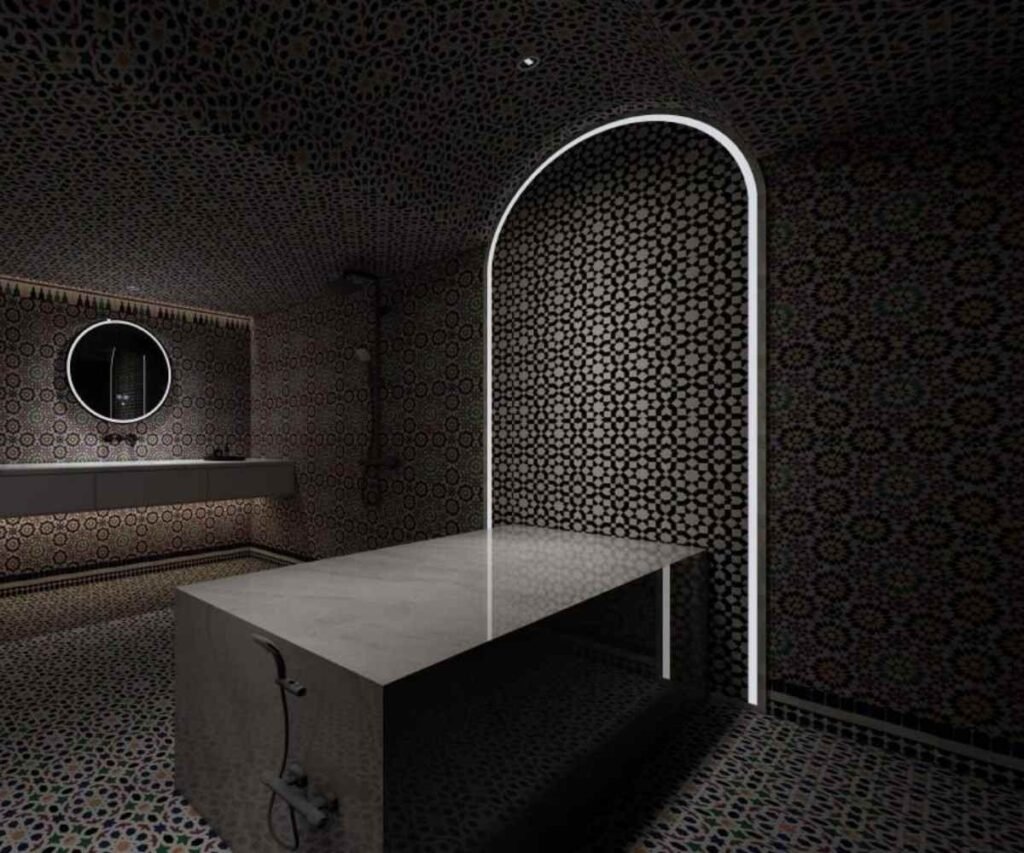 Authentic Moroccan bath interior at Queen Palace Hotel Spa Abu Dhabi, featuring intricate tile work and a traditional scrubbing table.